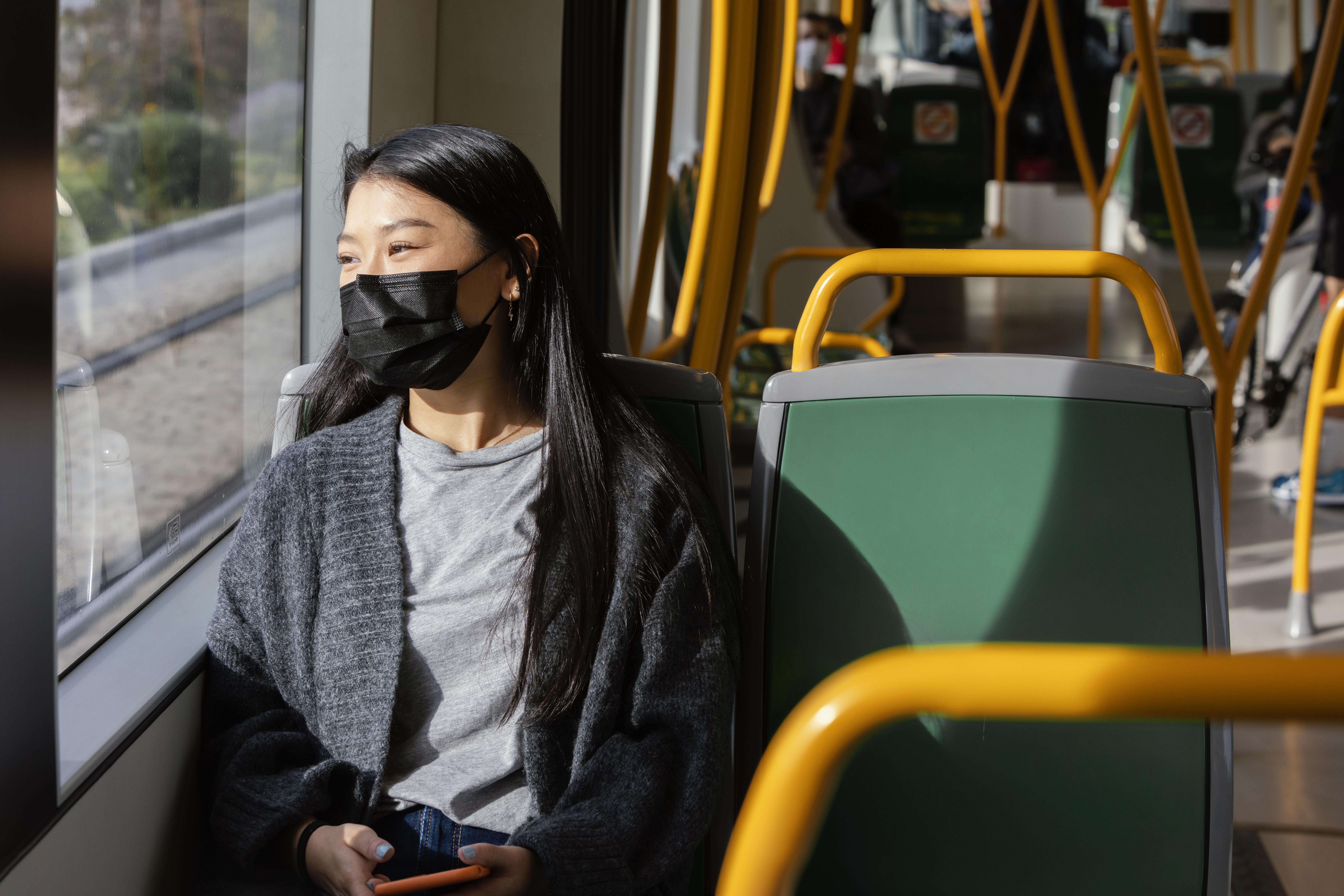Young woman with mask in bus